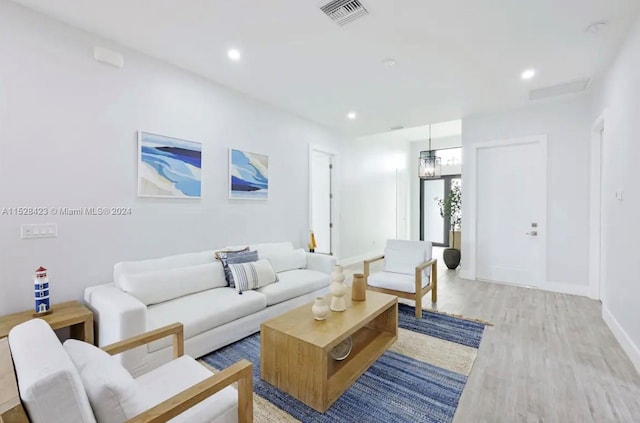 living room with a notable chandelier and light hardwood / wood-style floors