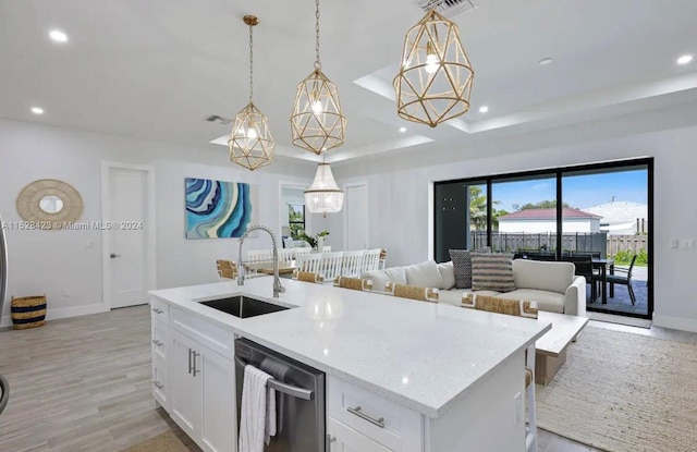 kitchen featuring pendant lighting, stainless steel dishwasher, white cabinets, a tray ceiling, and sink