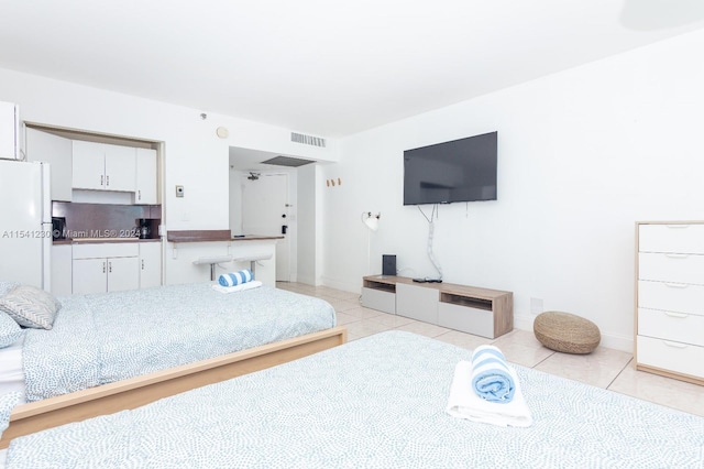 tiled bedroom with white fridge