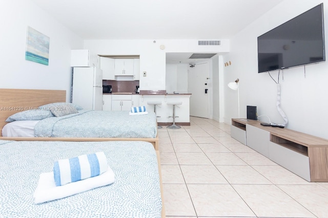 tiled bedroom featuring white refrigerator