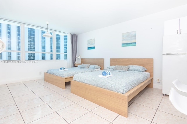 bedroom with light tile floors and white fridge