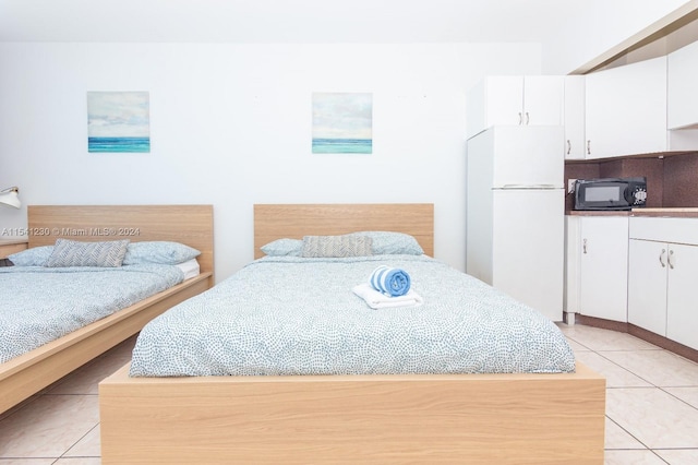 bedroom with light tile floors and white fridge