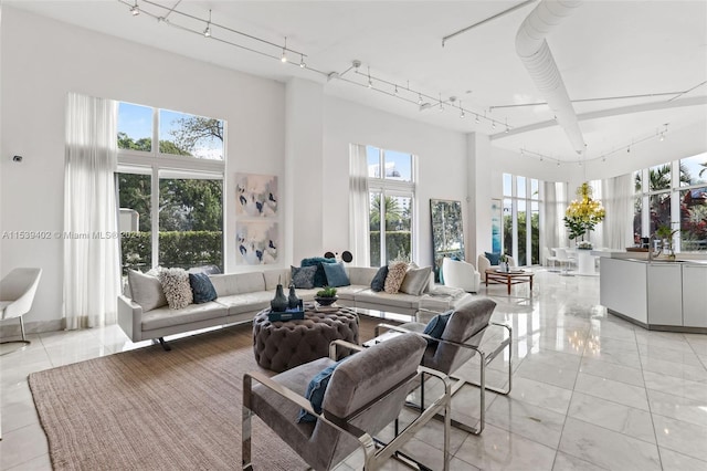 living room with light tile floors, rail lighting, and a wealth of natural light