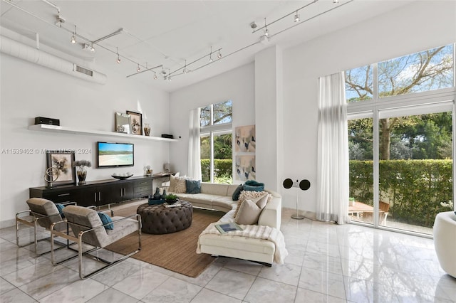 tiled living room featuring rail lighting and a wealth of natural light