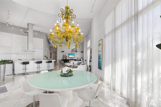 tiled dining space with track lighting and a chandelier