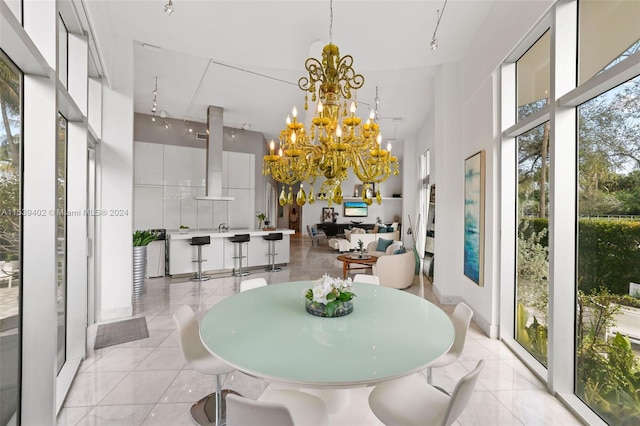 sunroom / solarium with a notable chandelier and rail lighting