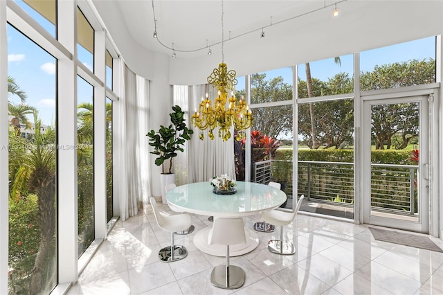 sunroom / solarium with an inviting chandelier and rail lighting