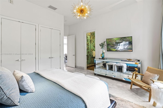 bedroom featuring a chandelier, multiple closets, and light tile flooring