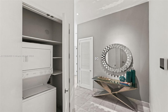 laundry area featuring light tile floors and stacked washer and dryer