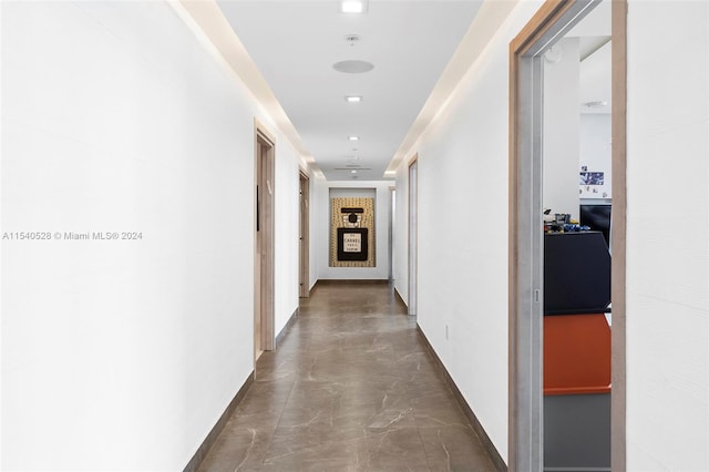 hallway with dark tile floors