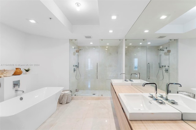 bathroom with shower with separate bathtub, tile flooring, vanity with extensive cabinet space, and dual sinks