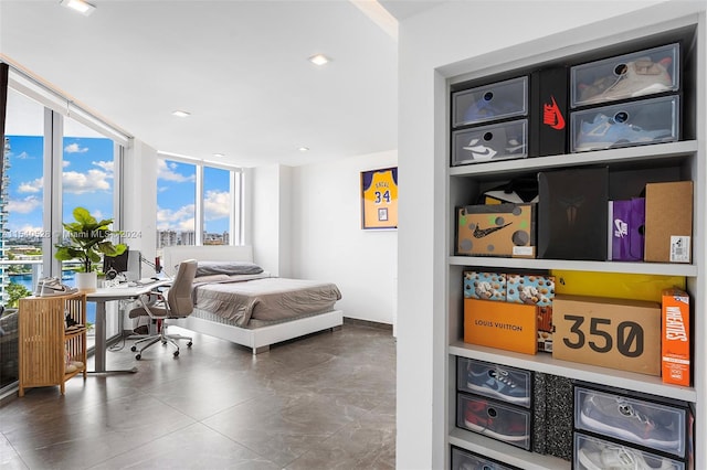 bedroom with dark tile floors and expansive windows