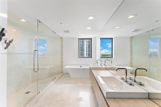 bathroom with shower with separate bathtub, tile floors, double sink, and large vanity