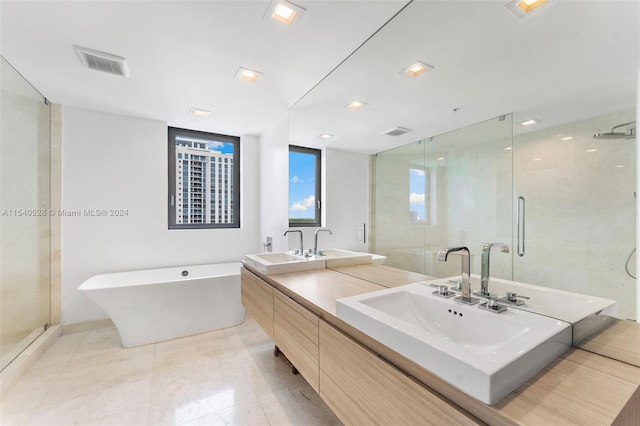 bathroom featuring double sink, shower with separate bathtub, tile floors, and oversized vanity