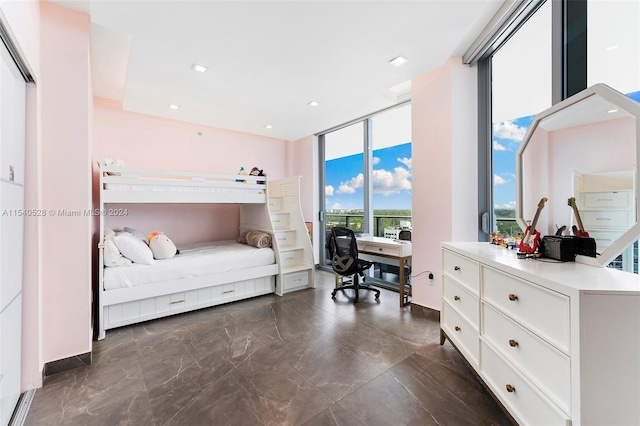 bedroom featuring dark tile floors and expansive windows