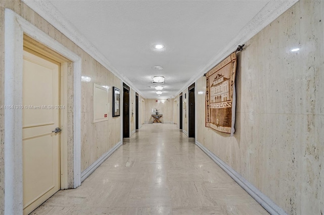 hallway with crown molding and light tile floors