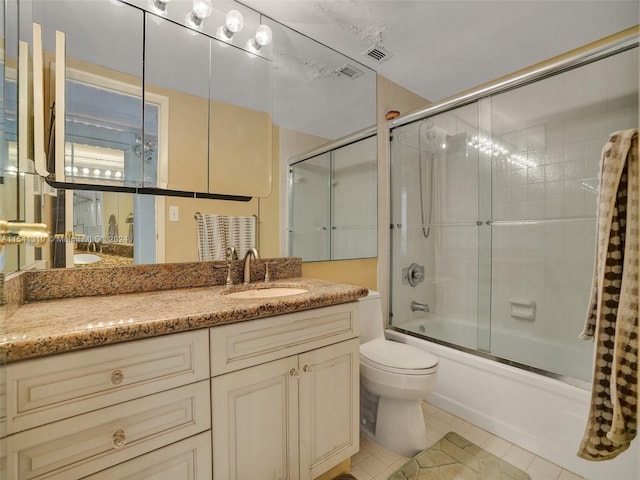 full bathroom featuring shower / bath combination with glass door, tile floors, oversized vanity, and toilet