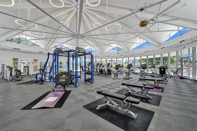 gym with high vaulted ceiling and ceiling fan