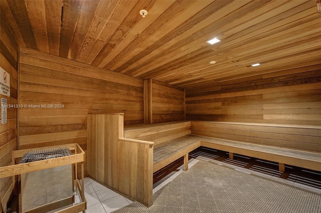 view of sauna / steam room featuring wooden walls, tile flooring, and wooden ceiling