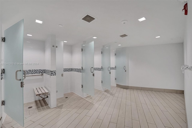 bathroom with a shower with door and tile floors