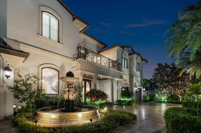 exterior space with a balcony and stucco siding