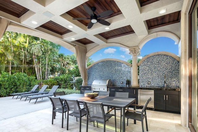 view of patio / terrace featuring a ceiling fan, outdoor dining space, grilling area, and an outdoor kitchen