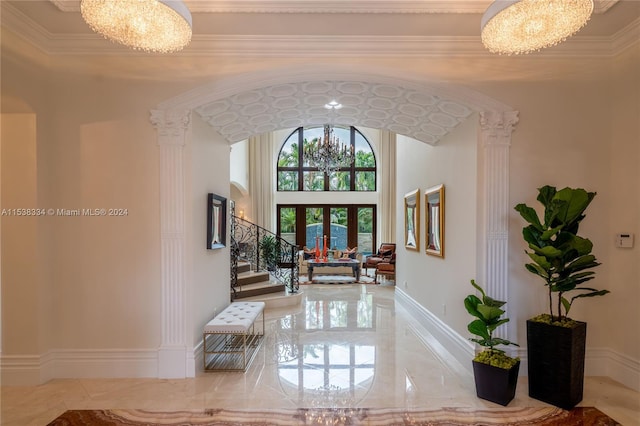 corridor featuring french doors, ornamental molding, and a notable chandelier