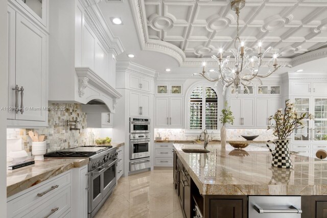 kitchen featuring a warming drawer, backsplash, a sink, a kitchen island with sink, and appliances with stainless steel finishes