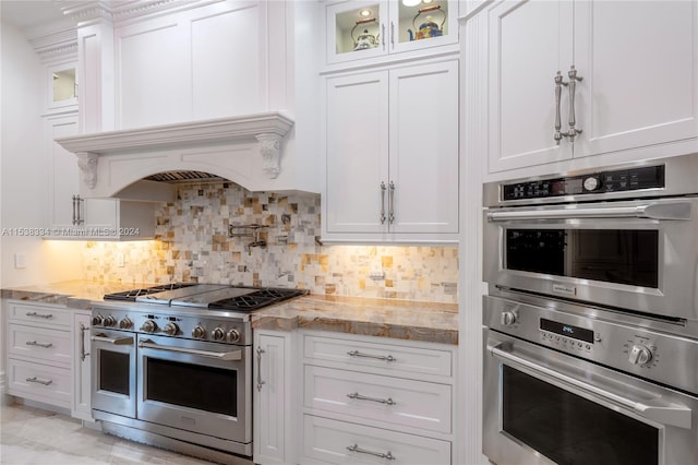 kitchen featuring decorative backsplash, light stone counters, white cabinetry, and stainless steel appliances