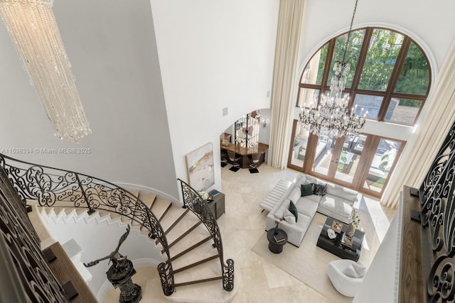 living room with an inviting chandelier, arched walkways, and a high ceiling