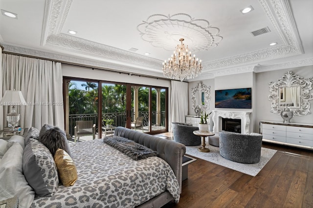 bedroom featuring a tray ceiling, a premium fireplace, dark wood-style floors, access to exterior, and visible vents