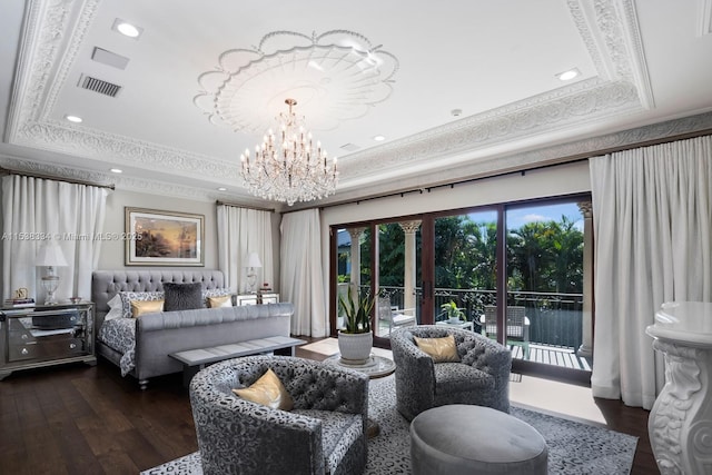 bedroom featuring wood finished floors, a notable chandelier, a tray ceiling, and visible vents