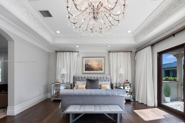 bedroom featuring ornamental molding, visible vents, an inviting chandelier, and a raised ceiling