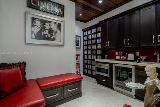 bar with sink, crown molding, decorative backsplash, wood ceiling, and beverage cooler