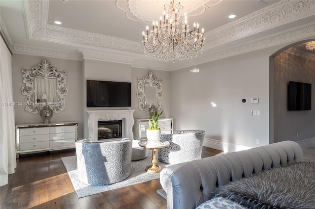 living room featuring a tray ceiling, dark hardwood / wood-style flooring, a high end fireplace, and ornamental molding