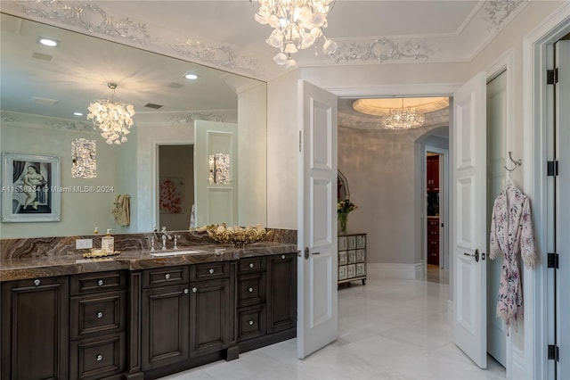 bathroom with vanity, ornamental molding, and a notable chandelier