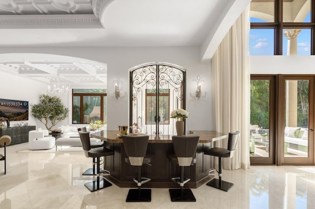 dining space with marble finish floor, arched walkways, and french doors
