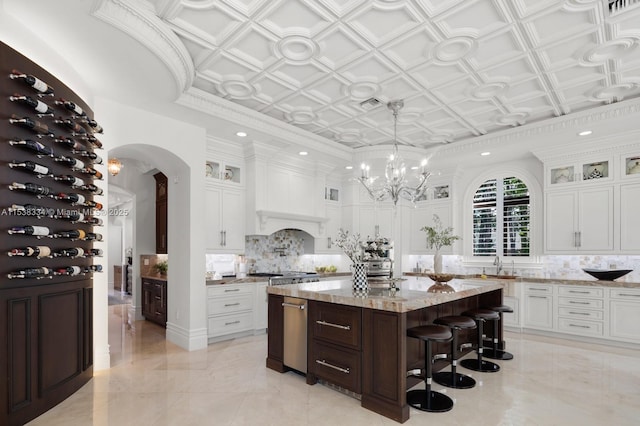 kitchen with white cabinetry, backsplash, an ornate ceiling, and a kitchen island