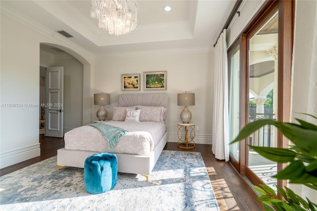 bedroom featuring a chandelier, a tray ceiling, dark hardwood / wood-style floors, and ornamental molding