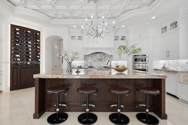 kitchen featuring an ornate ceiling, backsplash, double oven, dishwasher, and arched walkways