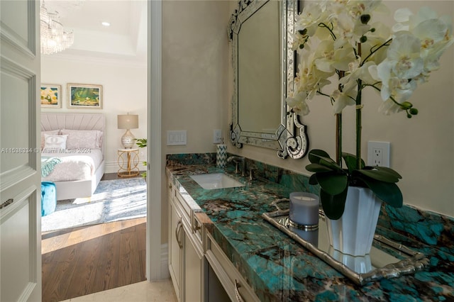 bathroom featuring a chandelier, wood-type flooring, vanity, and crown molding