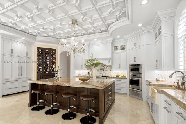kitchen featuring a spacious island, a warming drawer, stainless steel double oven, white cabinets, and decorative backsplash