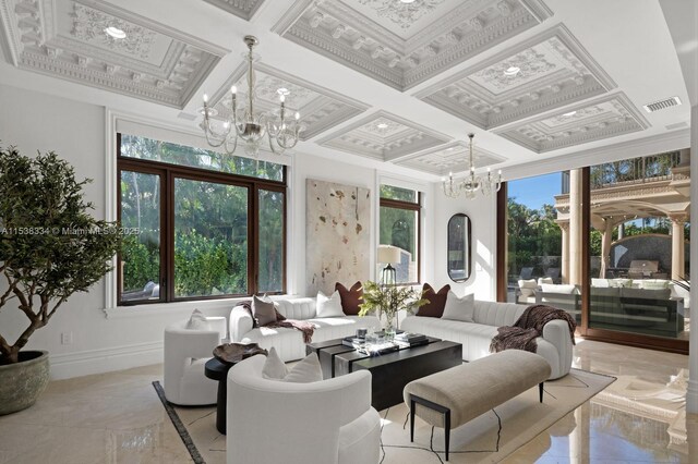 living area with an inviting chandelier, plenty of natural light, baseboards, and visible vents