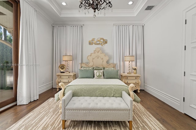 bedroom featuring wood finished floors, a chandelier, crown molding, and a raised ceiling