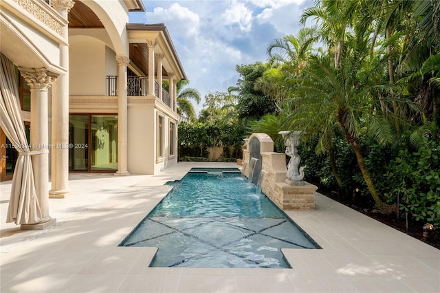 view of swimming pool featuring pool water feature and a patio area