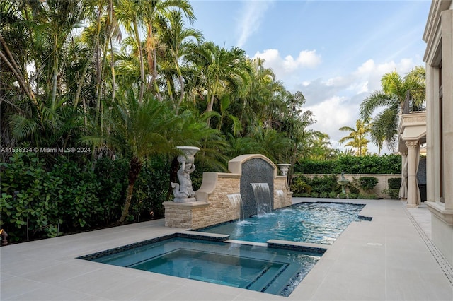 view of pool with pool water feature and an in ground hot tub