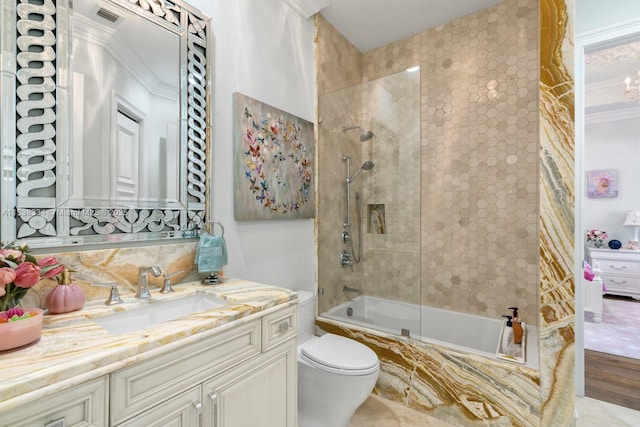 bathroom with visible vents, toilet, tiled shower / bath combo, and vanity