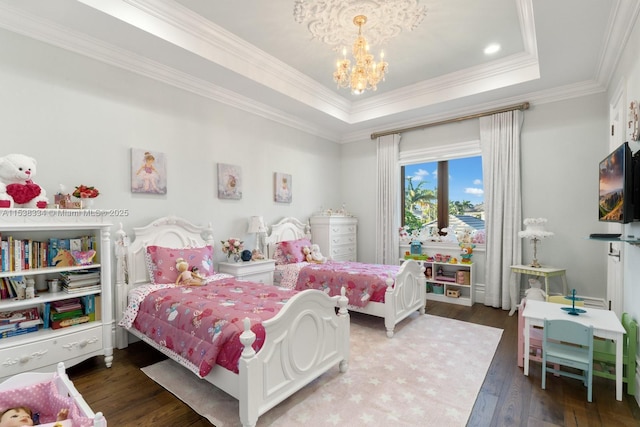 bedroom featuring a notable chandelier, hardwood / wood-style flooring, a tray ceiling, and crown molding