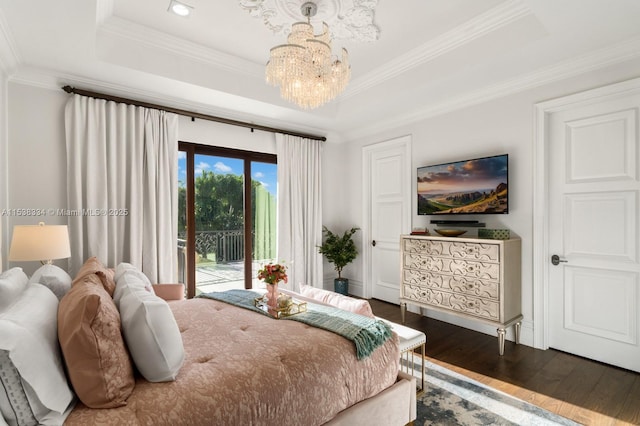 bedroom with a chandelier, crown molding, dark wood-type flooring, access to exterior, and a tray ceiling
