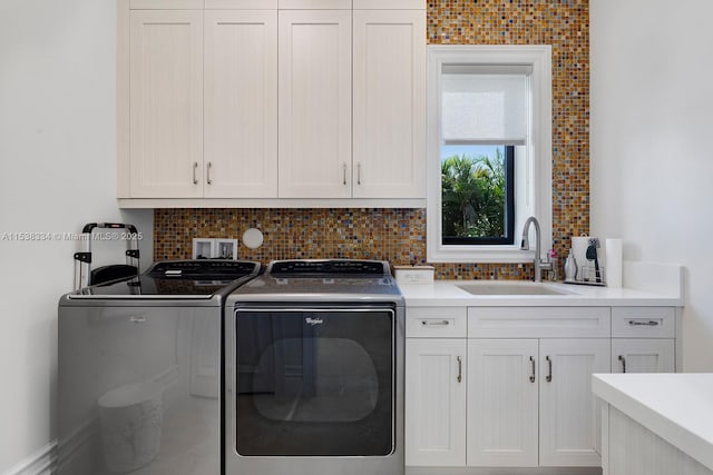 washroom featuring a sink, washer and clothes dryer, and cabinet space